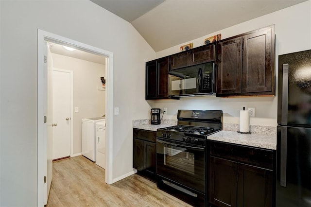 kitchen with black appliances, washer and clothes dryer, light wood finished floors, lofted ceiling, and light countertops