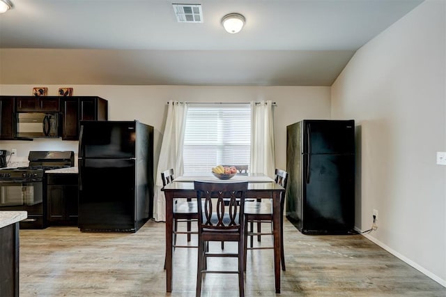 dining space featuring visible vents, light wood-style flooring, and baseboards