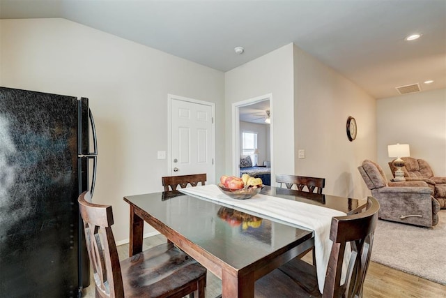 dining area featuring light wood finished floors, visible vents, recessed lighting, and vaulted ceiling