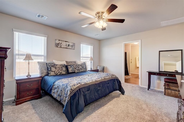 carpeted bedroom featuring a ceiling fan, baseboards, visible vents, and connected bathroom