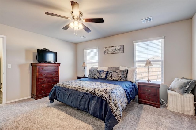 carpeted bedroom featuring visible vents, baseboards, and a ceiling fan