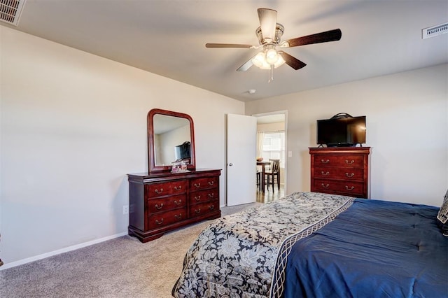 carpeted bedroom with visible vents, baseboards, and ceiling fan