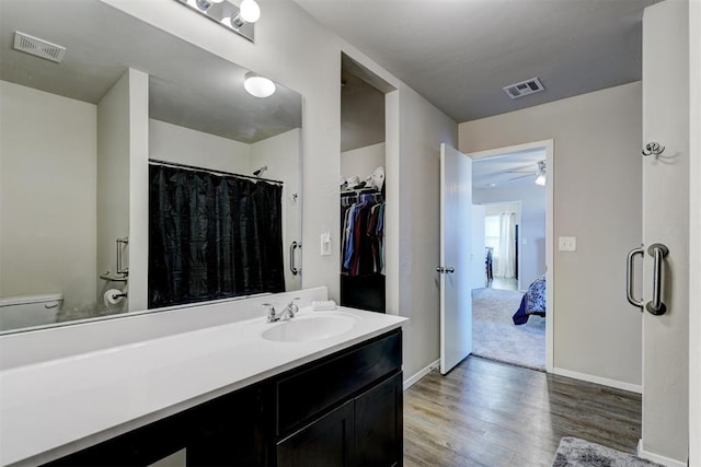 bathroom featuring vanity, wood finished floors, visible vents, and baseboards