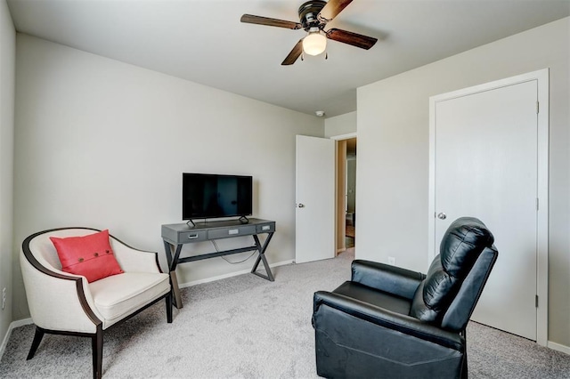 living area featuring baseboards, a ceiling fan, and carpet floors