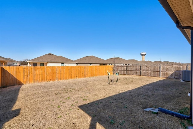 view of yard with central air condition unit and a fenced backyard