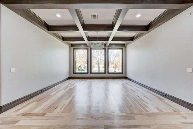 spare room featuring beam ceiling, wood finished floors, visible vents, and coffered ceiling