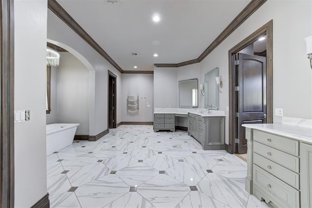 full bath with baseboards, ornamental molding, two vanities, recessed lighting, and a soaking tub