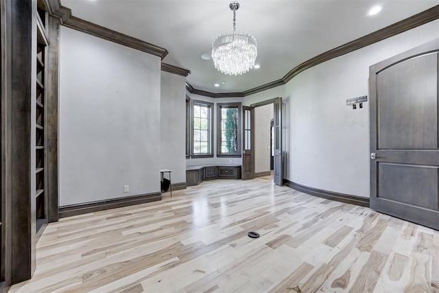 empty room featuring baseboards, light wood-style floors, and crown molding