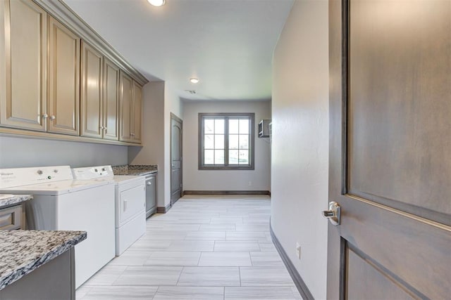 washroom featuring cabinet space, baseboards, and washing machine and clothes dryer