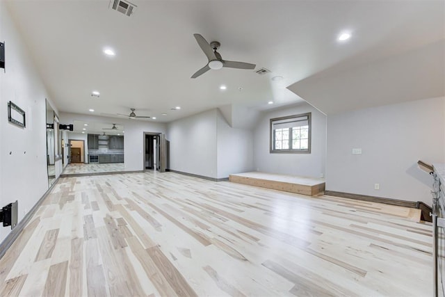 unfurnished living room featuring visible vents, light wood-style flooring, and a barn door