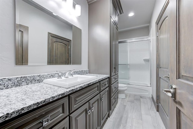 full bathroom with combined bath / shower with glass door, recessed lighting, toilet, and vanity