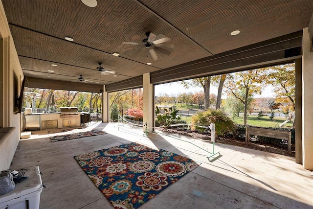 view of patio with grilling area, an outdoor kitchen, and a ceiling fan