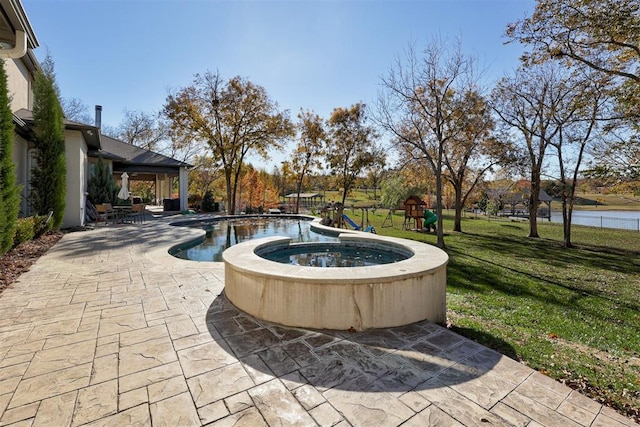 outdoor pool with playground community, a lawn, and a patio area