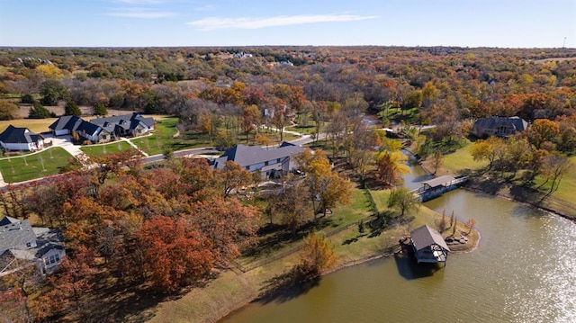 birds eye view of property featuring a water view and a wooded view