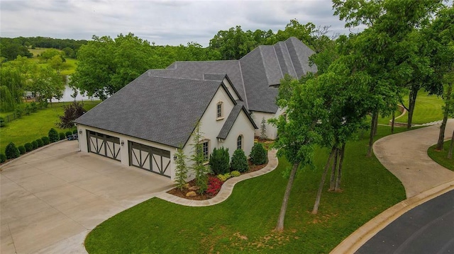 2747 Walking Woods Trl, Edmond, OK 73049 - view of front of home with roof with shingles, stucco siding, concrete driveway, and a front lawn