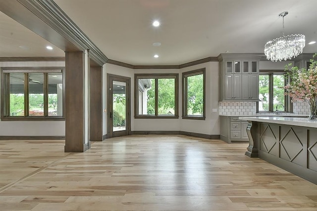 2747 Walking Woods Trl, Edmond, OK 73049 - kitchen with gray cabinetry, baseboards, ornamental molding, light countertops, and light wood-type flooring