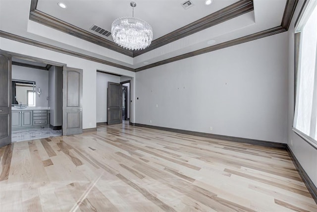 2747 Walking Woods Trl, Edmond, OK 73049 - unfurnished room featuring a chandelier, ornamental molding, light wood-type flooring, a raised ceiling, and baseboards