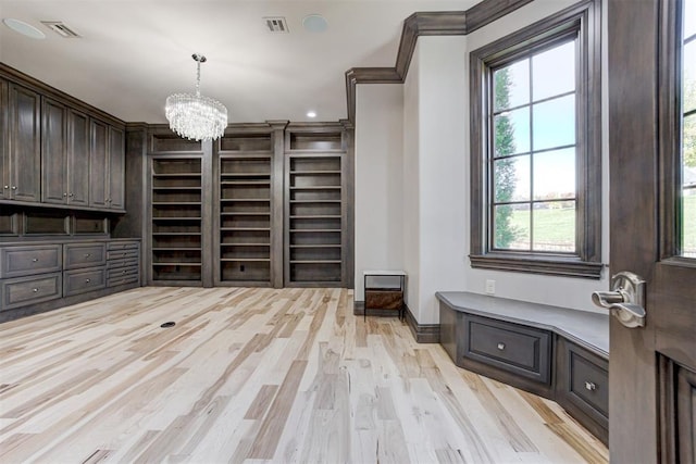 2747 Walking Woods Trl, Edmond, OK 73049 - mudroom with a chandelier, light wood finished floors, baseboards, crown molding, and built in shelves