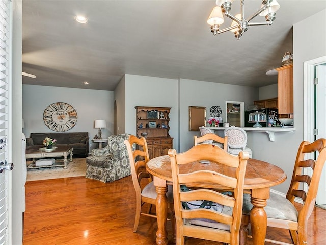 dining space featuring light wood finished floors, a chandelier, and recessed lighting