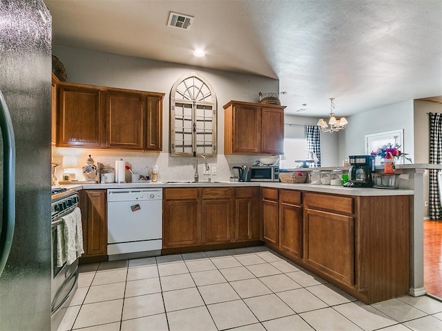 kitchen with visible vents, light countertops, appliances with stainless steel finishes, a peninsula, and a sink