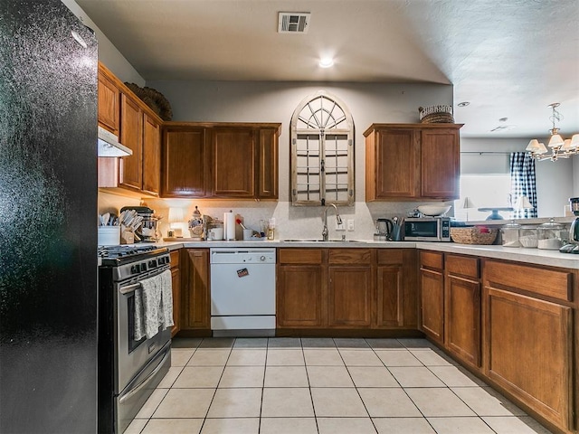 kitchen with white dishwasher, freestanding refrigerator, a sink, under cabinet range hood, and gas range