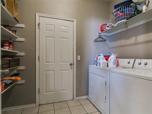 washroom featuring light tile patterned floors, independent washer and dryer, cabinet space, and baseboards