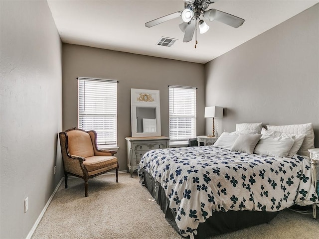 bedroom featuring light carpet, visible vents, a ceiling fan, and baseboards