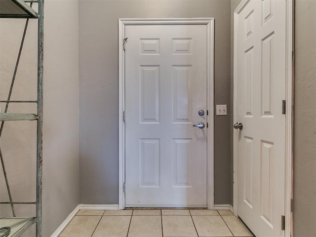 entryway with light tile patterned floors and baseboards