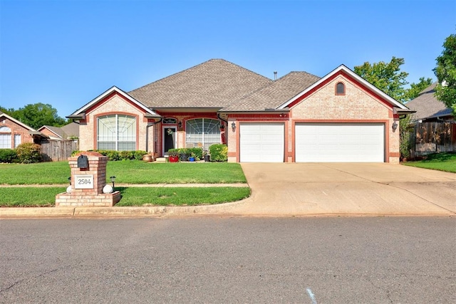 view of front facade featuring driveway, fence, an attached garage, a front yard, and brick siding