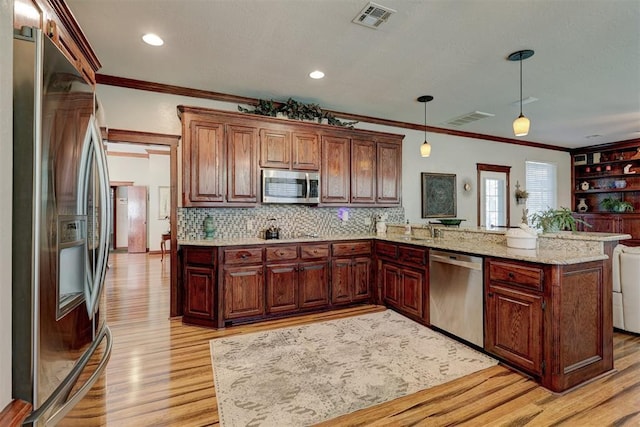 kitchen featuring hanging light fixtures, a peninsula, visible vents, and stainless steel appliances