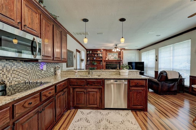 kitchen with visible vents, a sink, open floor plan, stainless steel appliances, and a peninsula