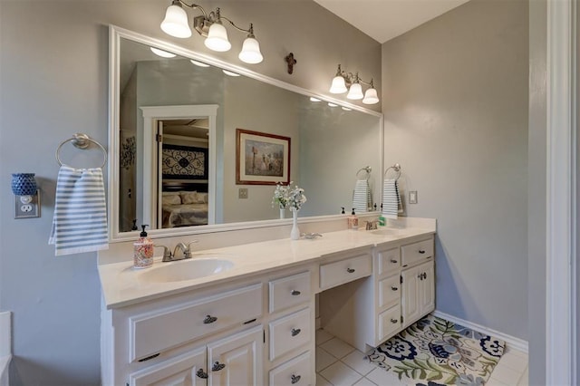 bathroom featuring double vanity, baseboards, tile patterned floors, and a sink