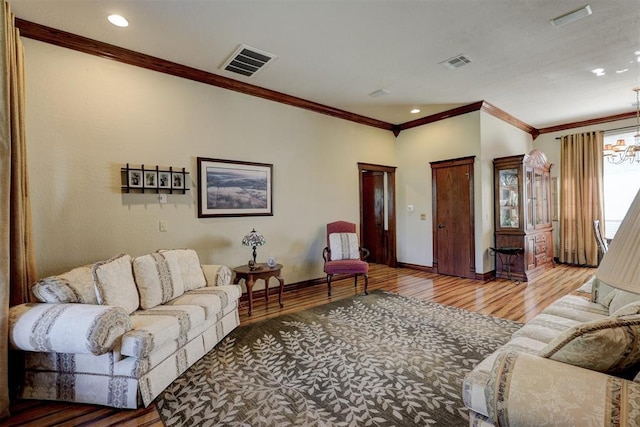 living room featuring visible vents, baseboards, wood finished floors, and ornamental molding