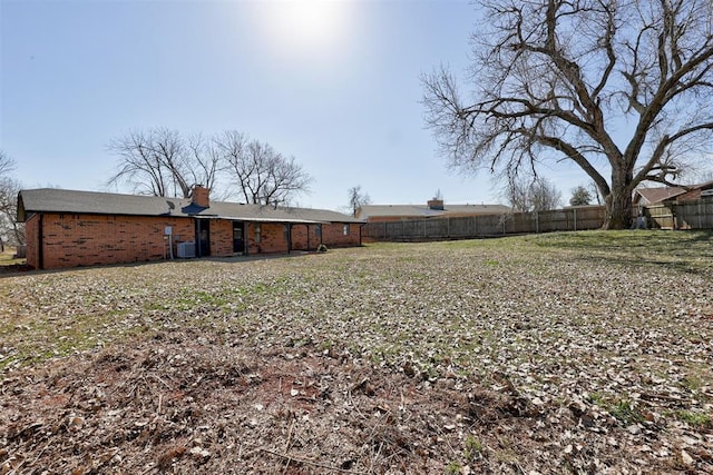 view of yard featuring central AC unit and fence