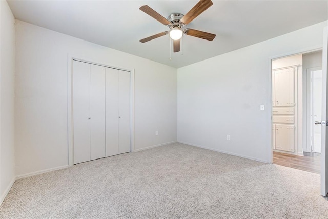 unfurnished bedroom with a closet, carpet floors, baseboards, and ceiling fan