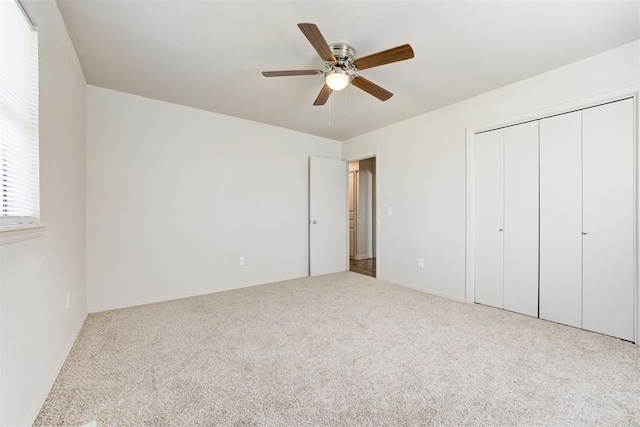 unfurnished bedroom featuring a closet, carpet flooring, and a ceiling fan