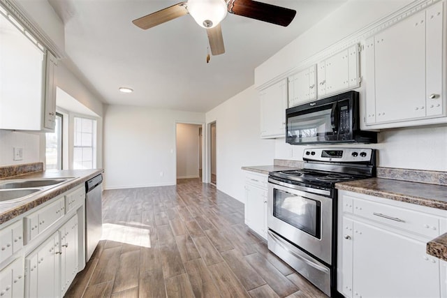 kitchen featuring a sink, white cabinetry, appliances with stainless steel finishes, light wood finished floors, and ceiling fan