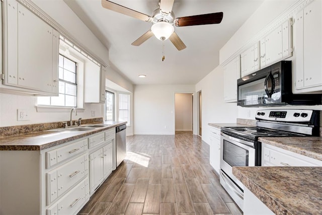 kitchen with light wood-style flooring, ceiling fan, a sink, appliances with stainless steel finishes, and white cabinetry