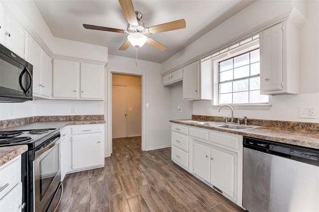 kitchen featuring a sink, wood finished floors, white cabinetry, stainless steel appliances, and ceiling fan