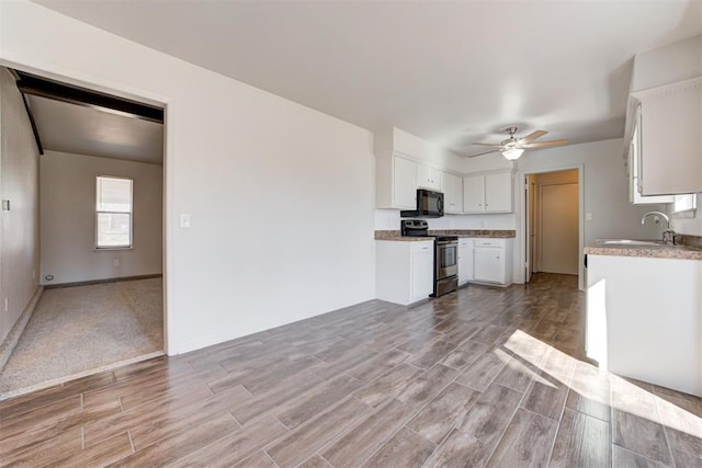 kitchen featuring a sink, white cabinetry, black microwave, stainless steel electric range oven, and ceiling fan