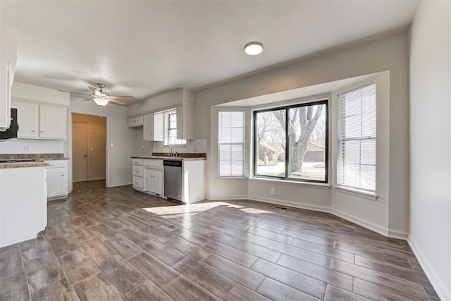 kitchen featuring a ceiling fan, baseboards, wood finish floors, white cabinets, and dishwasher