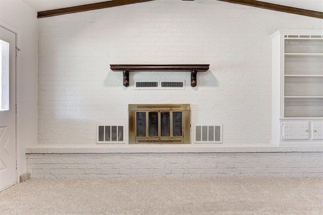 interior space with beam ceiling, carpet flooring, visible vents, and brick wall