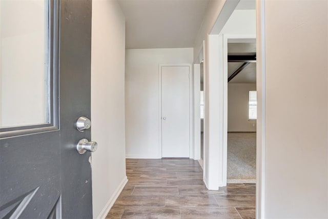 corridor featuring baseboards and wood tiled floor