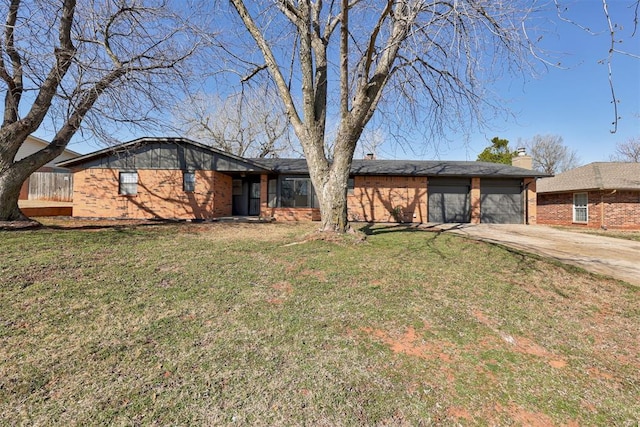 mid-century home featuring brick siding, driveway, a chimney, and a front lawn