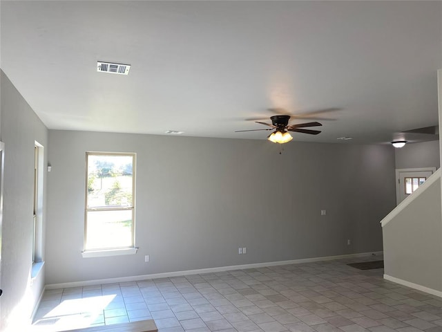 spare room featuring light tile patterned floors, visible vents, baseboards, and ceiling fan