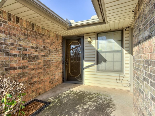 entrance to property featuring brick siding