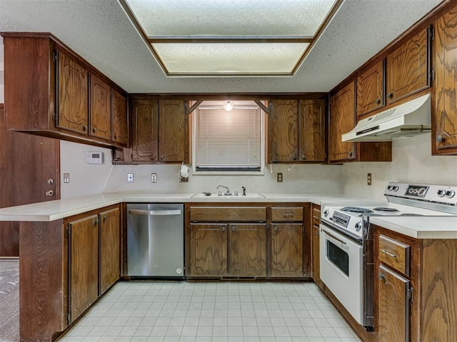 kitchen featuring electric stove, under cabinet range hood, a sink, stainless steel dishwasher, and a peninsula