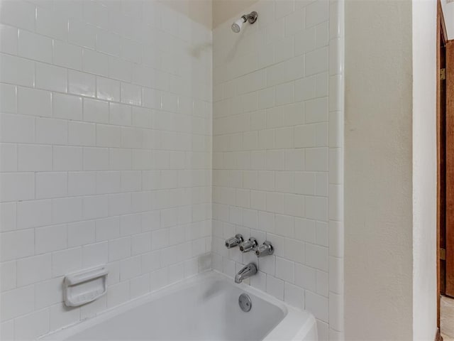 full bathroom with bathing tub / shower combination and a textured wall