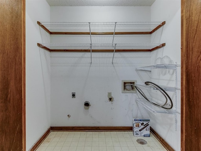 laundry area with electric dryer hookup, a textured ceiling, gas dryer hookup, and washer hookup