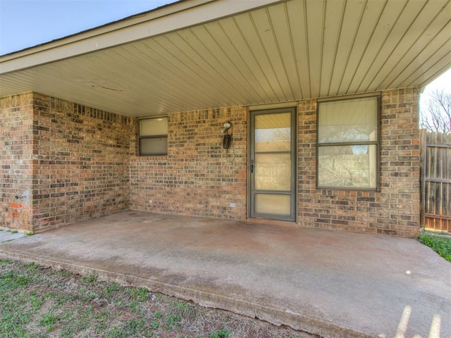 view of patio featuring an attached carport and fence